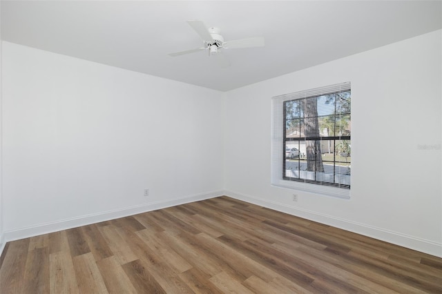 empty room with ceiling fan, baseboards, and wood finished floors