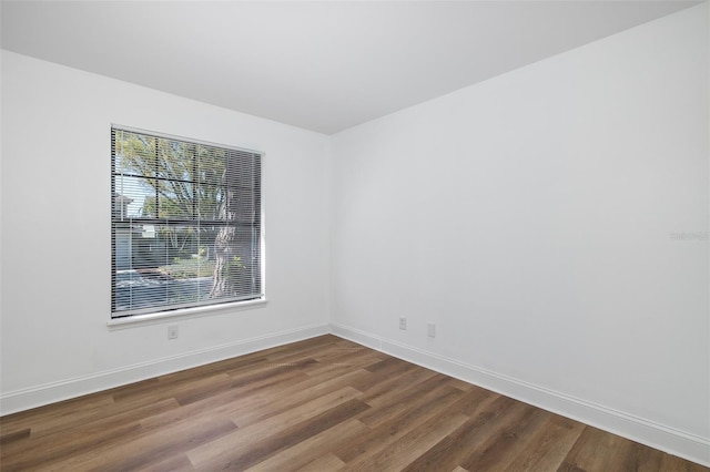 unfurnished room featuring baseboards and wood finished floors