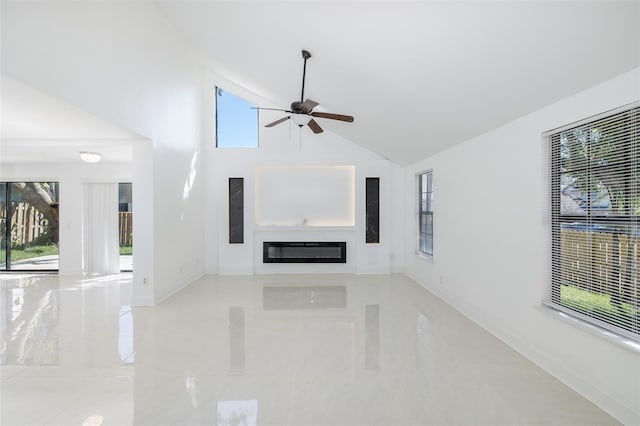 unfurnished living room with baseboards, high vaulted ceiling, a ceiling fan, and a glass covered fireplace