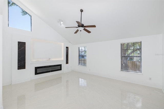 unfurnished living room with ceiling fan, high vaulted ceiling, a glass covered fireplace, and a wealth of natural light