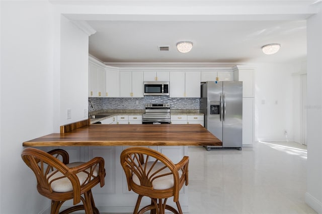 kitchen featuring stainless steel appliances, a sink, visible vents, and decorative backsplash