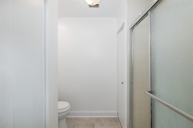 full bathroom featuring toilet, baseboards, and a tile shower