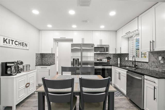 kitchen with a sink, visible vents, white cabinetry, and stainless steel appliances