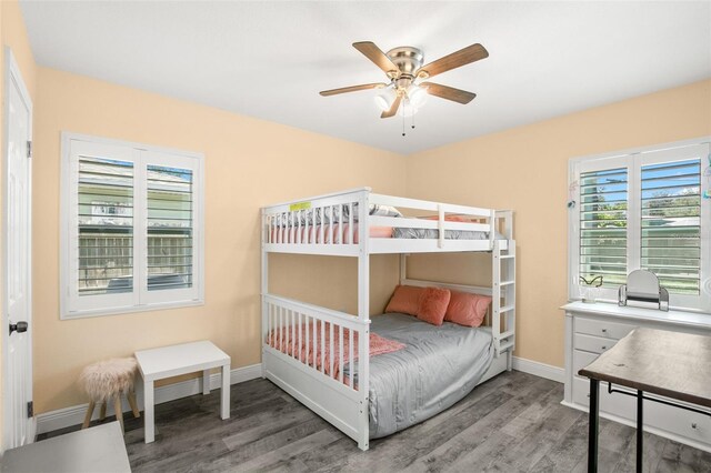 bedroom featuring baseboards, wood finished floors, and a ceiling fan