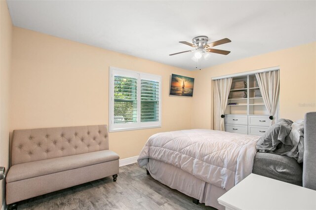 bedroom featuring ceiling fan, baseboards, and wood finished floors