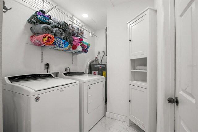 laundry area with baseboards, laundry area, water heater, washer and dryer, and marble finish floor