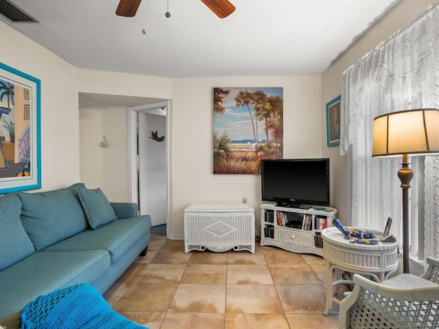 living room with ceiling fan, a textured ceiling, visible vents, and tile patterned flooring