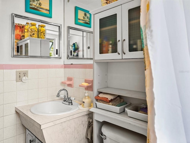 bathroom with wainscoting, vanity, and tile walls