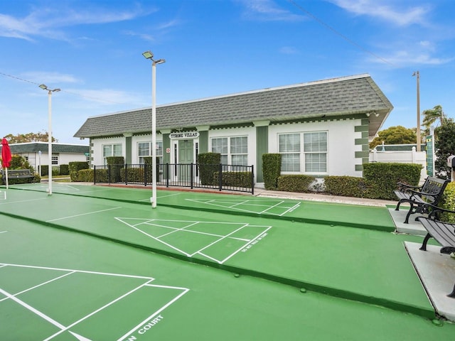 view of home's community with shuffleboard and fence