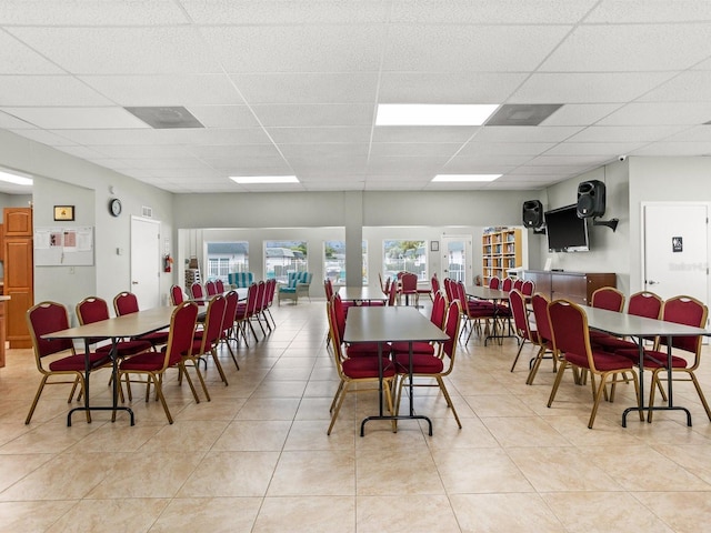 dining room featuring light tile patterned floors and a drop ceiling