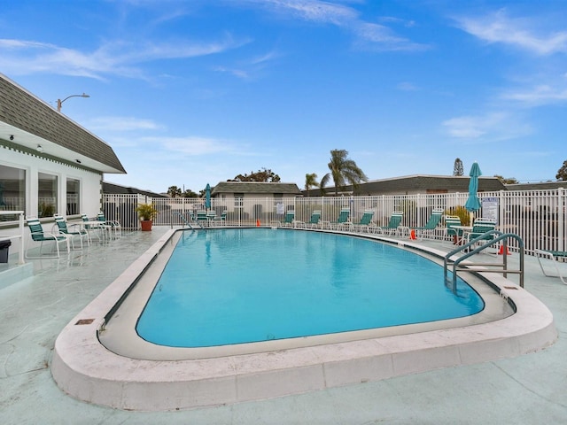 community pool featuring a patio area and fence