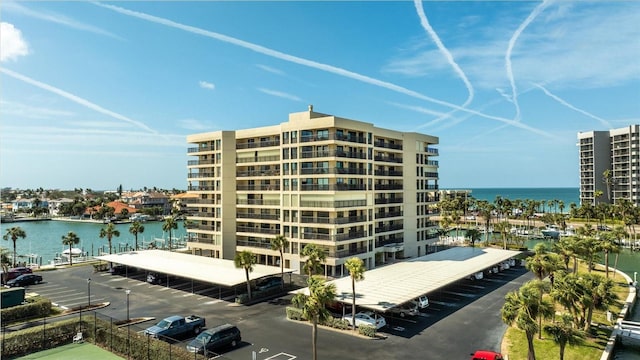 view of building exterior featuring uncovered parking and a water view