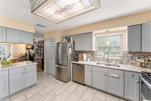 kitchen with visible vents, appliances with stainless steel finishes, gray cabinets, and a sink