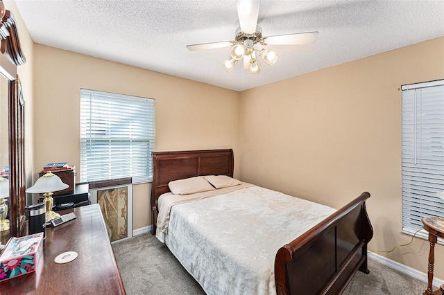 carpeted bedroom with a ceiling fan, baseboards, and a textured ceiling