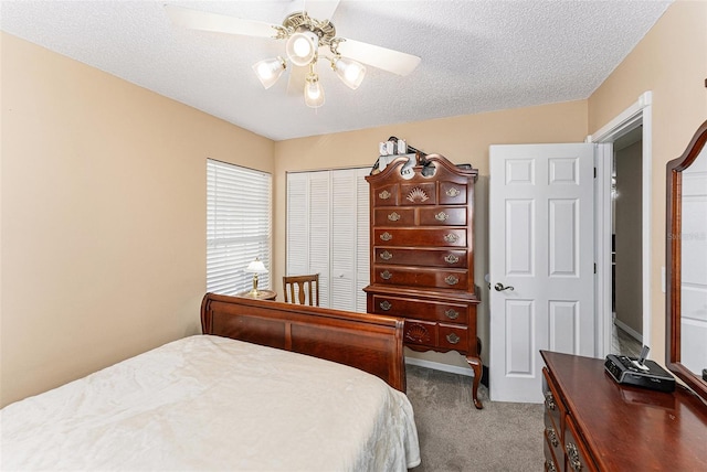 carpeted bedroom with a closet, a ceiling fan, and a textured ceiling