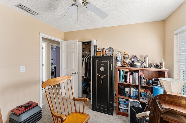 office area with a ceiling fan, carpet, visible vents, and a textured ceiling