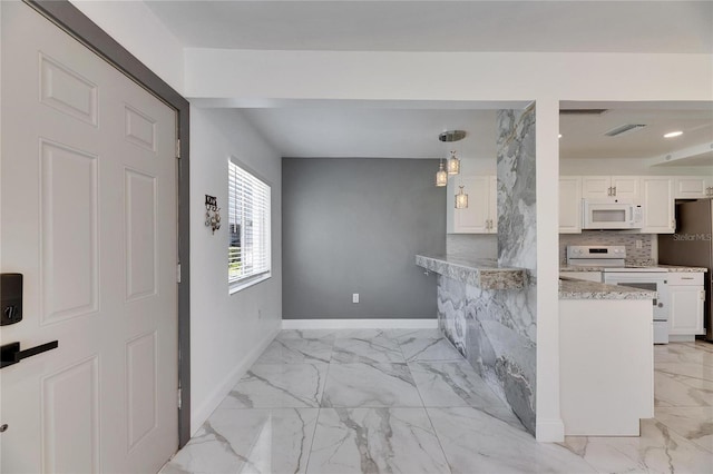 kitchen with white appliances, visible vents, baseboards, marble finish floor, and white cabinetry