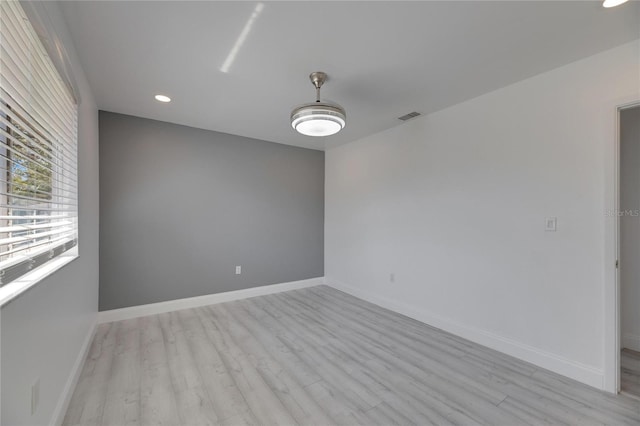 spare room with light wood-type flooring, visible vents, baseboards, and recessed lighting