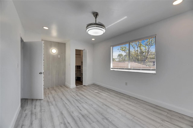 empty room featuring recessed lighting, wood finished floors, and baseboards