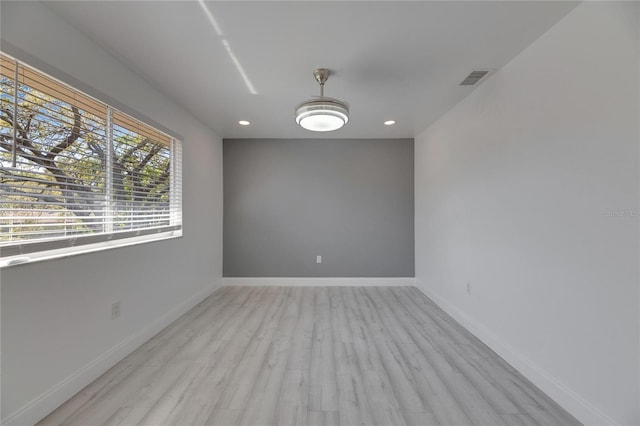 spare room with light wood finished floors, recessed lighting, visible vents, and baseboards