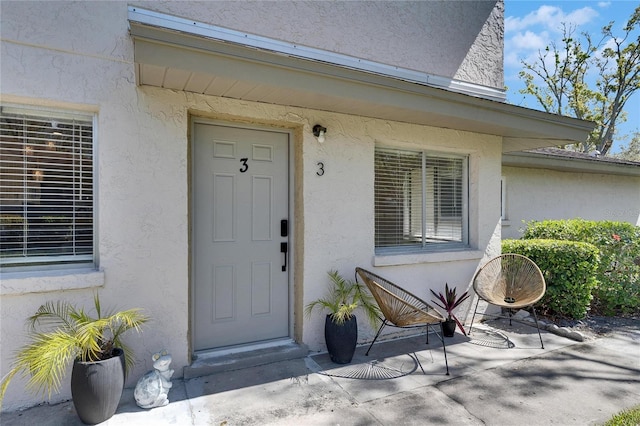 property entrance with stucco siding