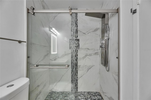 full bathroom with toilet and a marble finish shower