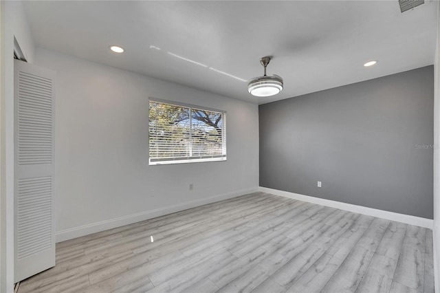 empty room with visible vents, baseboards, and wood finished floors