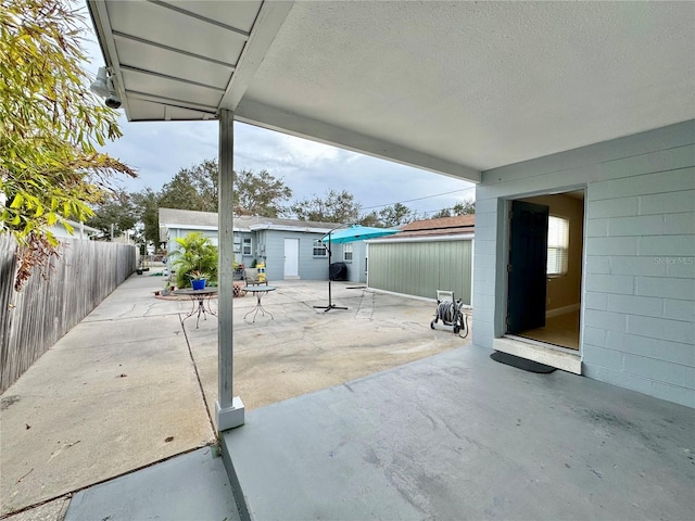 view of patio with fence and an outbuilding