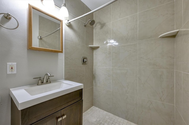 full bathroom with tiled shower and vanity