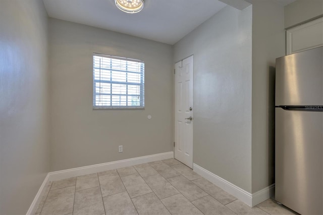 interior space featuring light tile patterned floors and baseboards