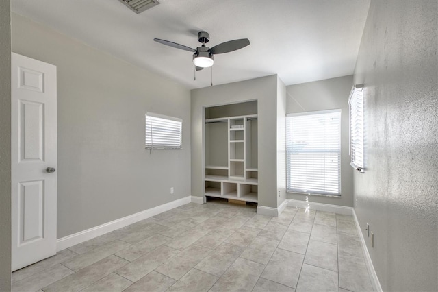unfurnished bedroom featuring a ceiling fan, baseboards, multiple windows, and visible vents