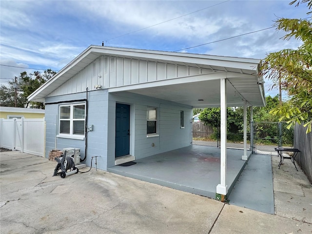 exterior space with an attached carport, fence, and a gate