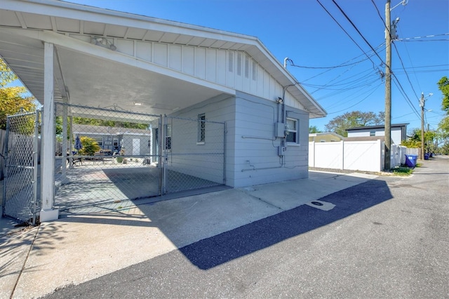 exterior space featuring a carport, driveway, fence, and a gate