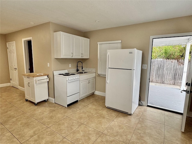 kitchen featuring light countertops, a sink, white appliances, and white cabinets