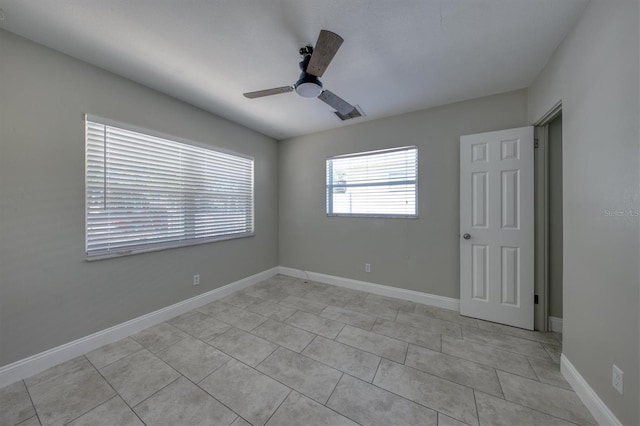 empty room featuring light tile patterned floors, baseboards, and ceiling fan