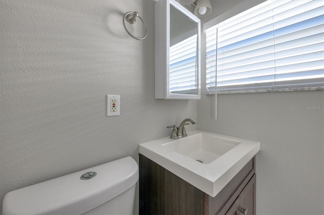 half bathroom with vanity and toilet