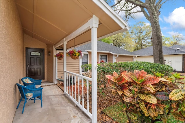 doorway to property featuring a porch and stucco siding