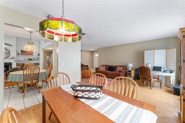 dining area with light wood-style flooring and a fireplace