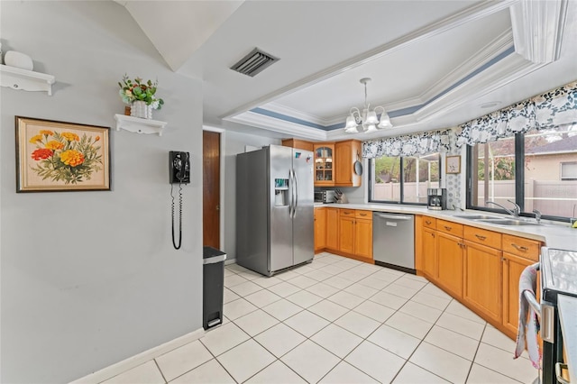 kitchen with a tray ceiling, light countertops, visible vents, appliances with stainless steel finishes, and a sink