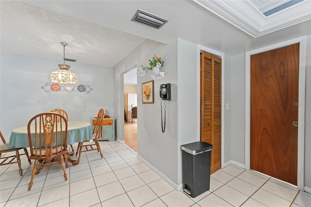 dining room featuring light tile patterned floors, baseboards, visible vents, and ornamental molding