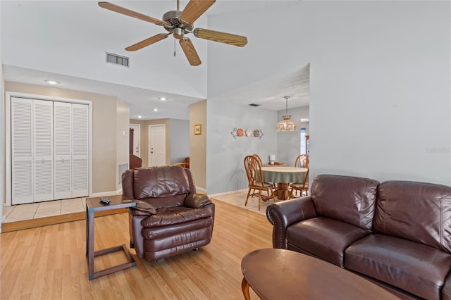 living area with a ceiling fan, baseboards, visible vents, and light wood finished floors