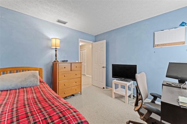 carpeted bedroom featuring baseboards, visible vents, and a textured ceiling