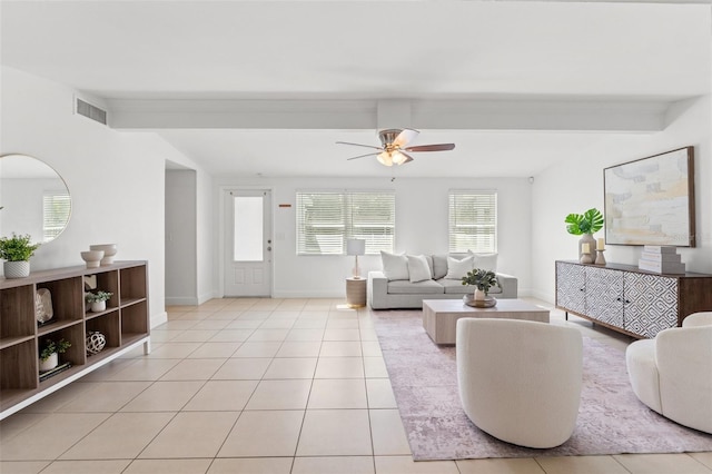 living room featuring light tile patterned floors, visible vents, and beamed ceiling