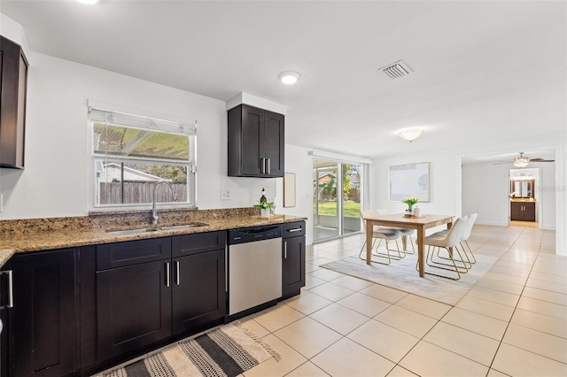 kitchen with light tile patterned floors, visible vents, light stone countertops, stainless steel dishwasher, and a sink