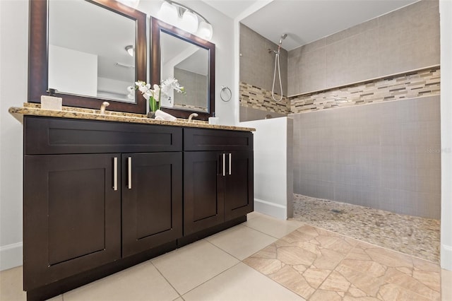 full bathroom with double vanity, tile patterned flooring, a walk in shower, and a sink