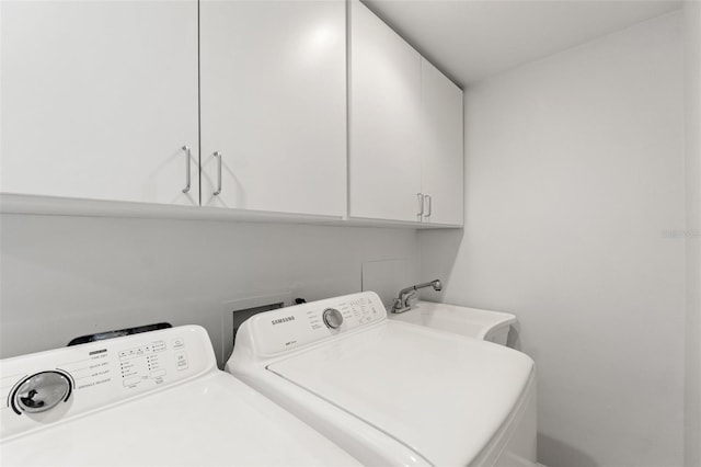 laundry area with cabinet space, a sink, and independent washer and dryer