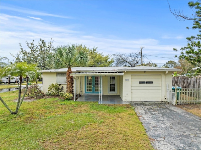 single story home with a garage, fence, driveway, french doors, and a front yard