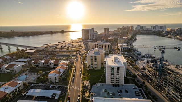 aerial view at dusk featuring a view of city and a water view