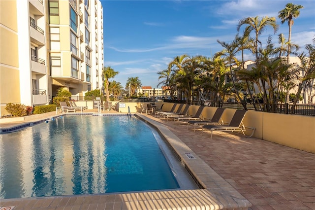 community pool with a patio and fence