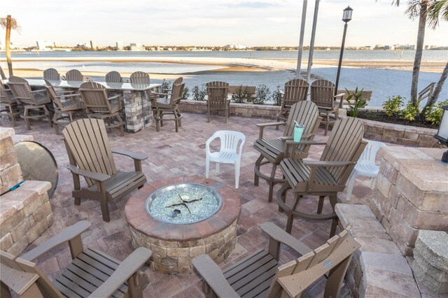 view of patio / terrace with an outdoor fire pit and a water view